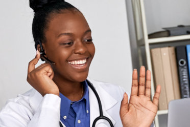 doctor smiling while holding a brocoli