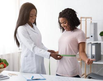 doctor measuring hips of the woman